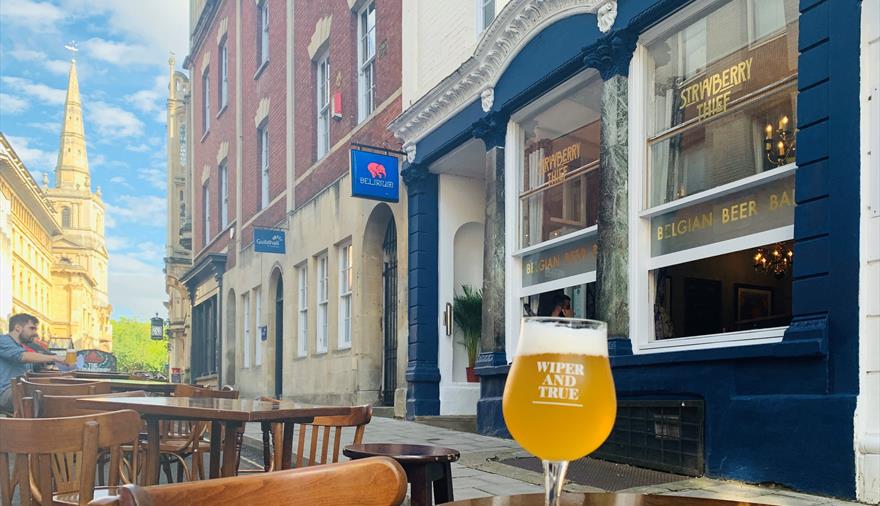 View outside The Strawberry Thief with beer on table