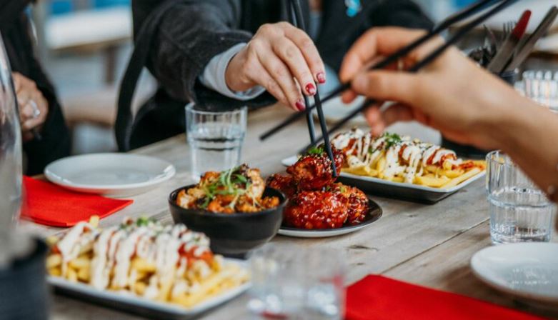 people eating dishes with chopsticks