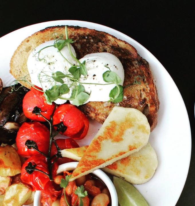 Full breakfast with toast, poached eggs, grilled halloumi and vine tomatoes