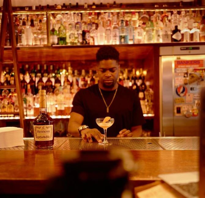 Man pouring cocktail at bar