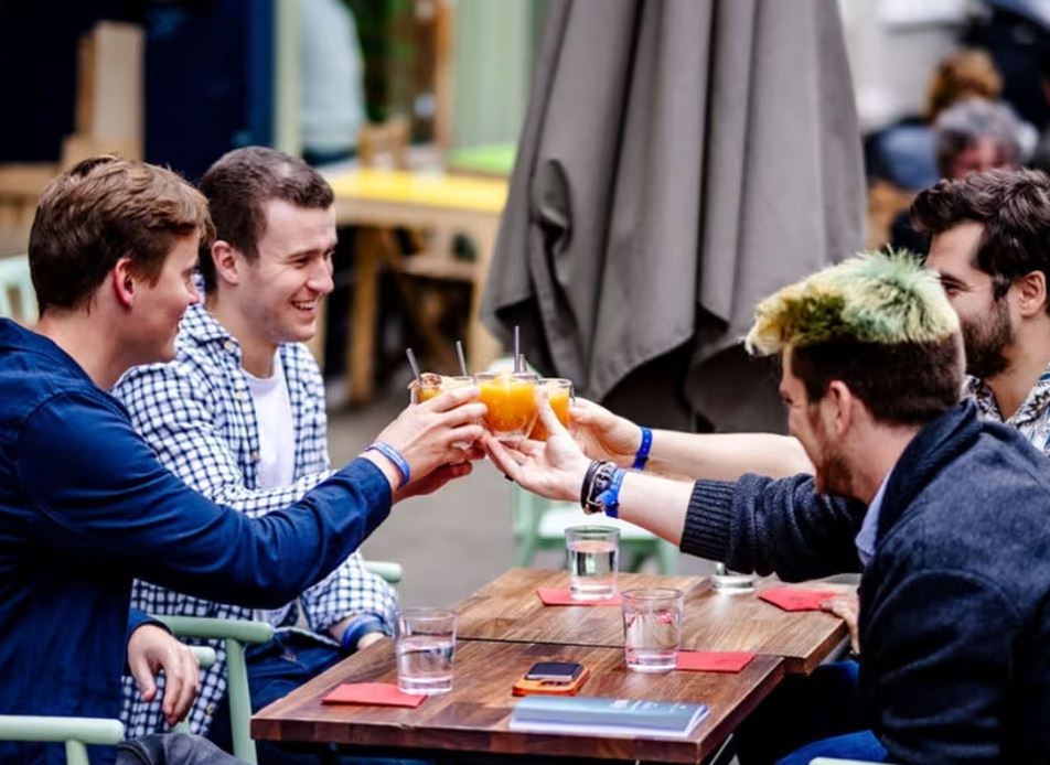 Group of men drinking cocktails outside