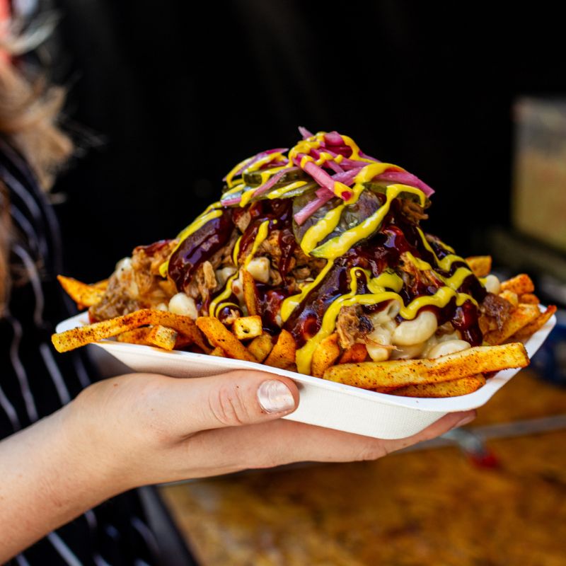 Close up of someone holding dirty fries