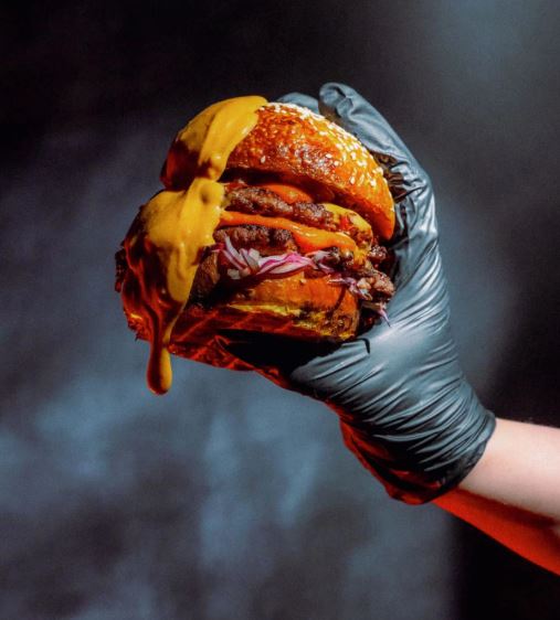 Hand holding cheese burger